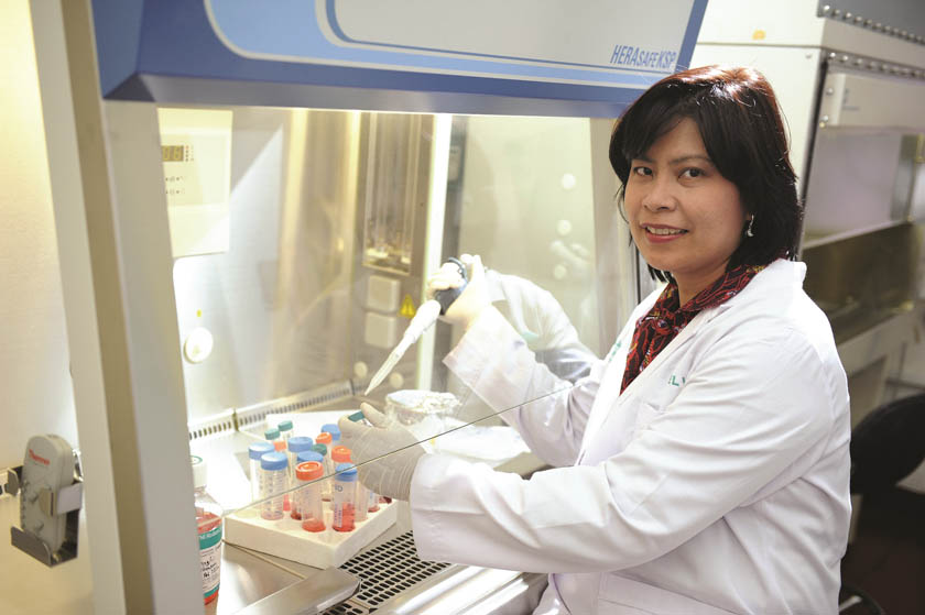 A female researcher in white coat is working in the laboratory